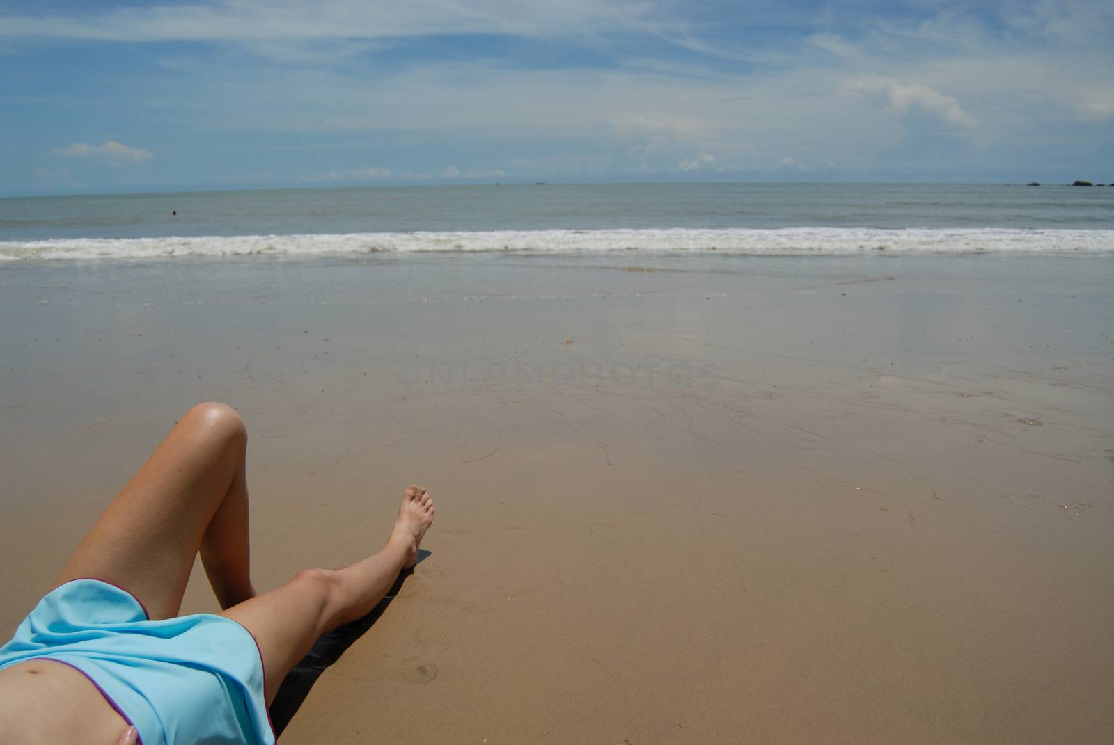 Stock photo of beautiful tall brunette woman on the beach in the by seawaters