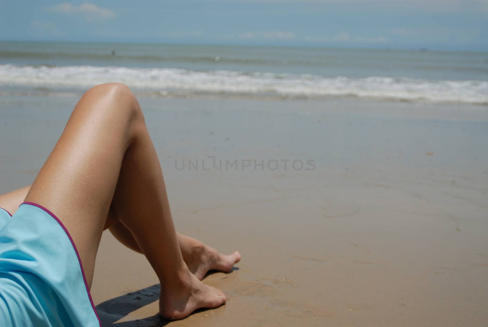 Stock photo of beautiful tall brunette woman on the beach in the by seawaters