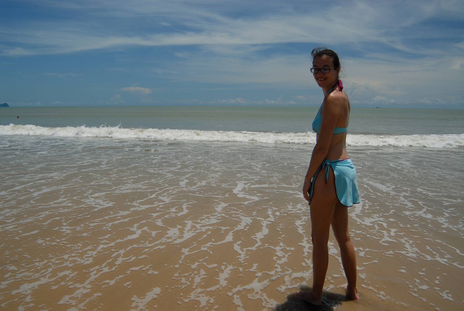 Stock photo of beautiful tall brunette woman on the beach in the by seawaters