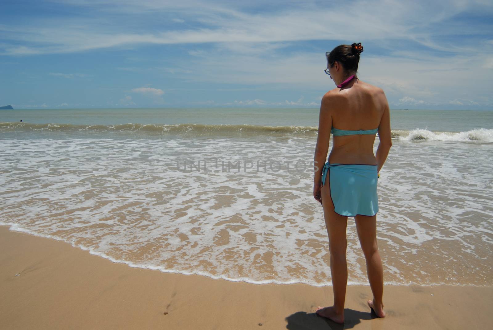 Stock photo of beautiful tall brunette woman on the beach in the tropics