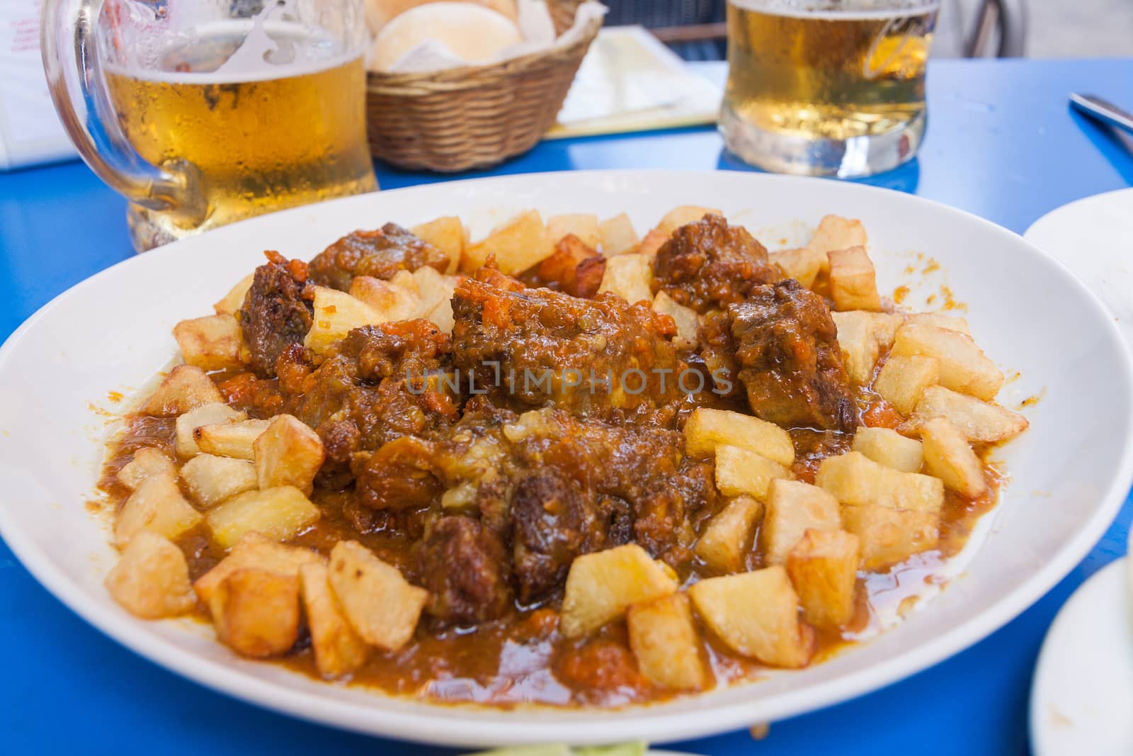 Bull tail stew with fried potatoes. Rustic Spanish style cuisine.