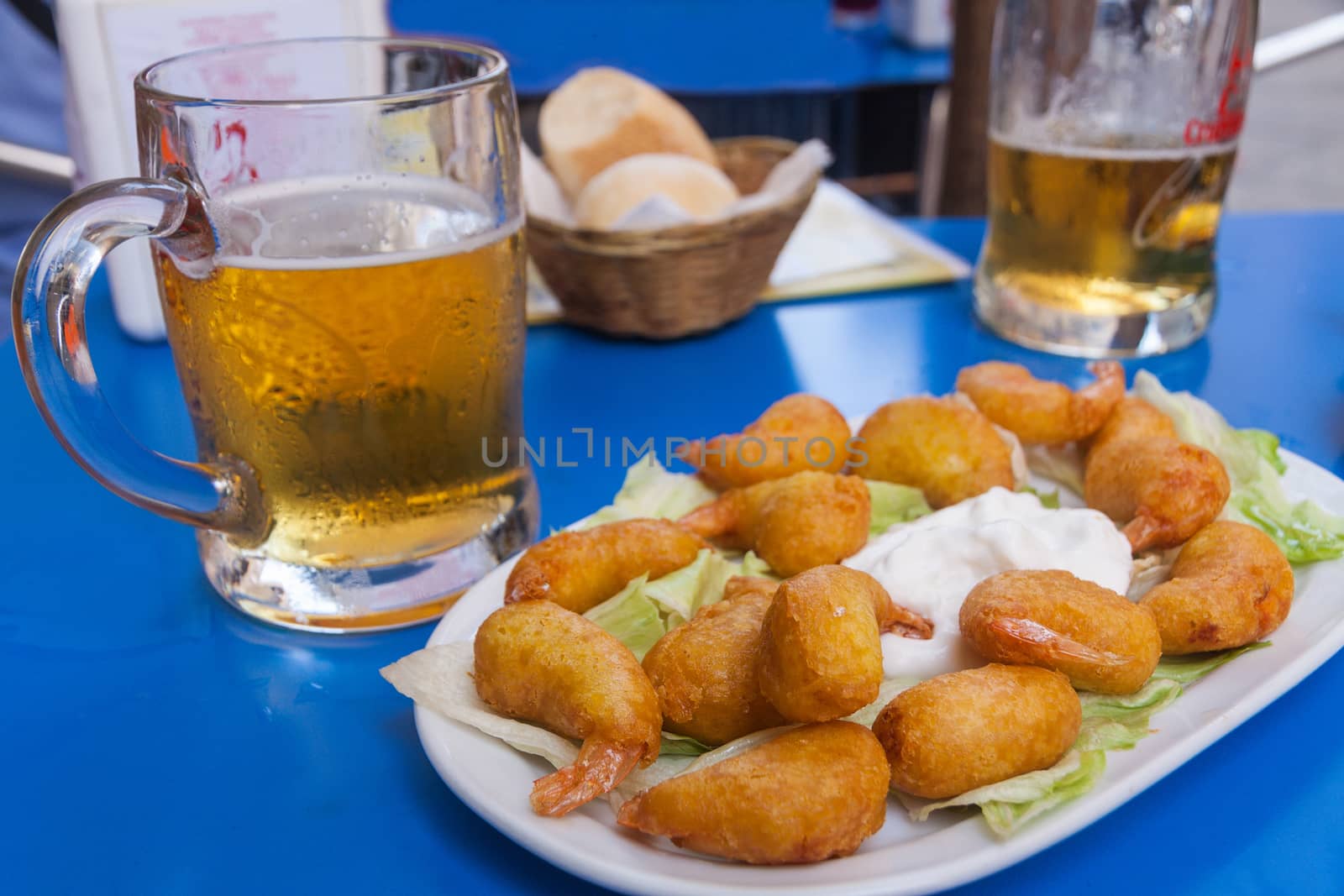 Plate of fried shrimps with lettuce leaves and sauce