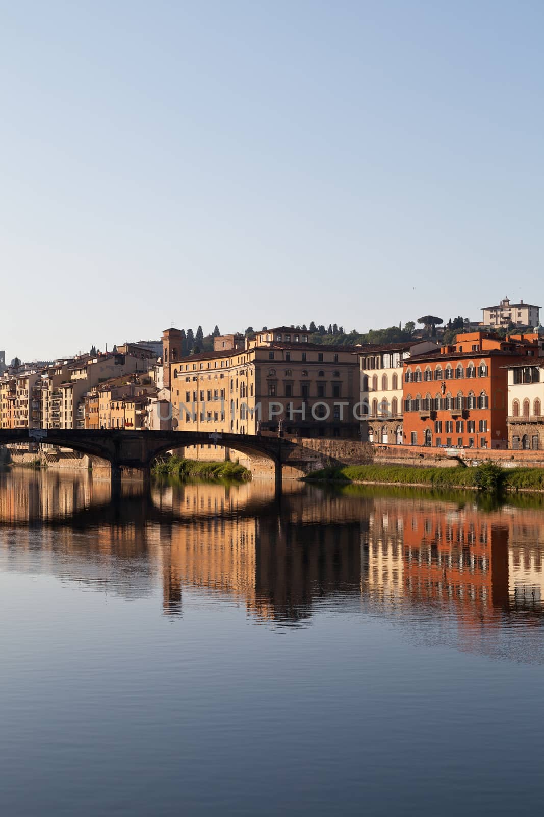 view on bridge on arno river in florence in italy with reflection