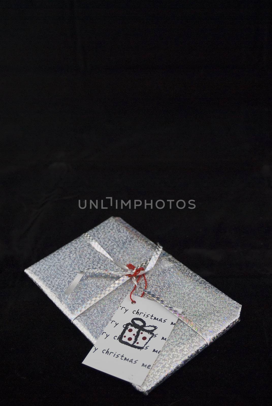 A silver christmas gift isloated on a black background