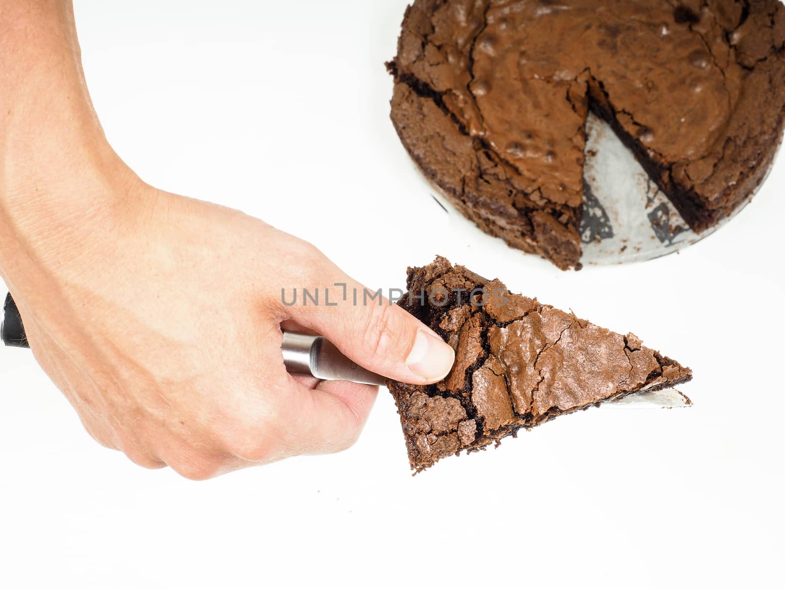 Person serving a slice of fresh made chocolated cake