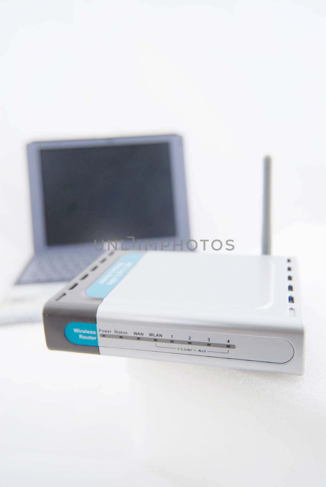 A modern silver laptop with wireless router