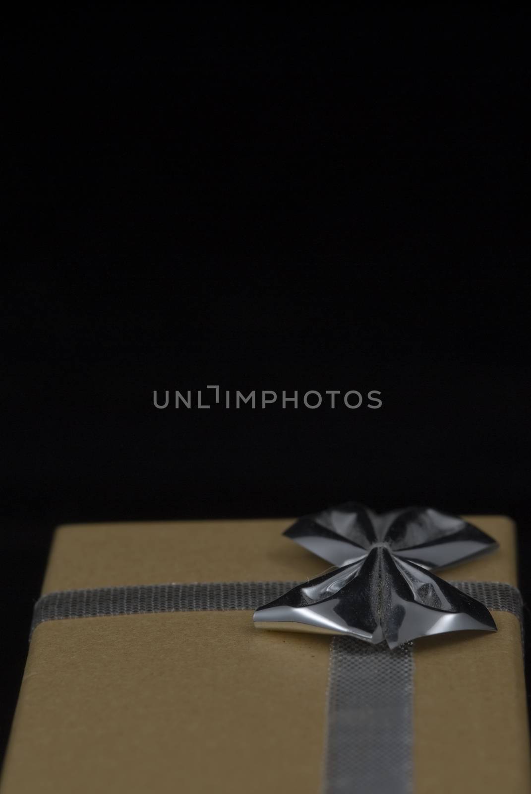 Christmas gift with silver bow on black background