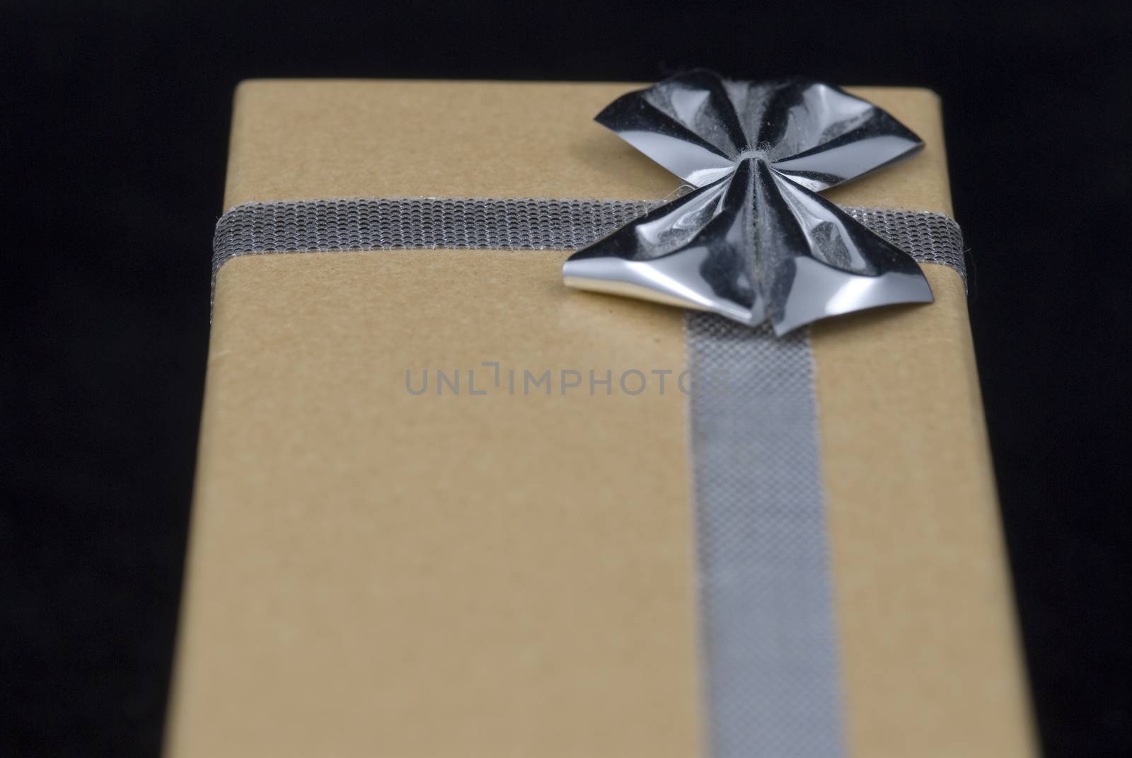 Christmas gift with silver bow on black background