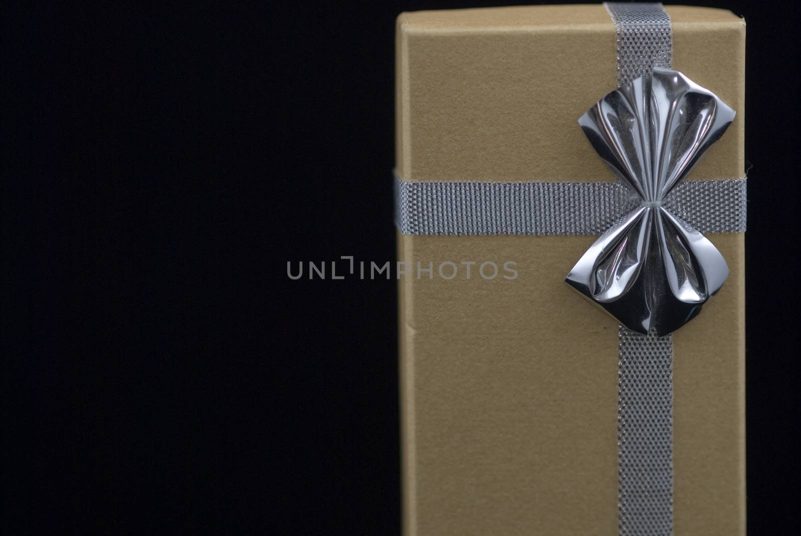 Christmas gift with silver bow on black background