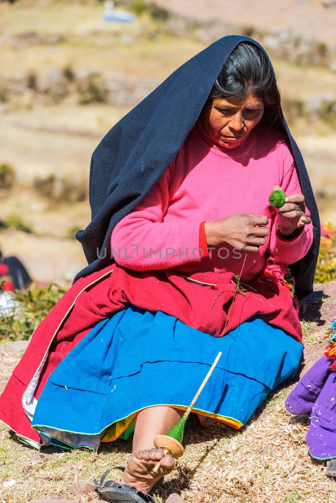 Puno, Peru - July 25, 2013: woman weaving in the peruvian Andes at Taquile Island on Puno Peru at july 25th, 2013.