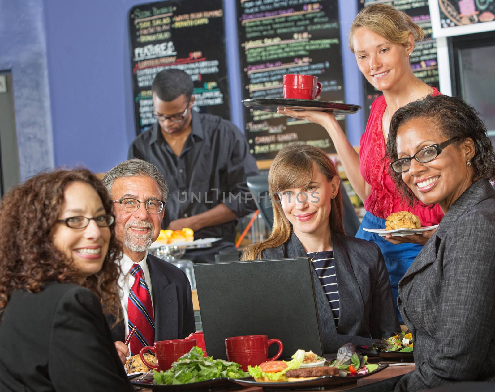 Happy group of people with laptop in cafe and barista