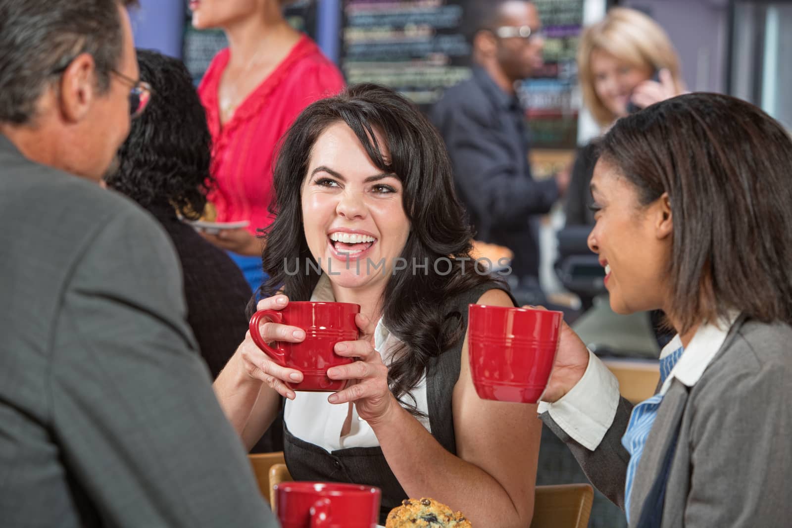 Laughing pretty woman with friends in coffee house