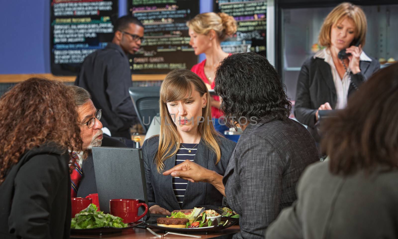 Skeptical woman with coworkers meeting during lunch