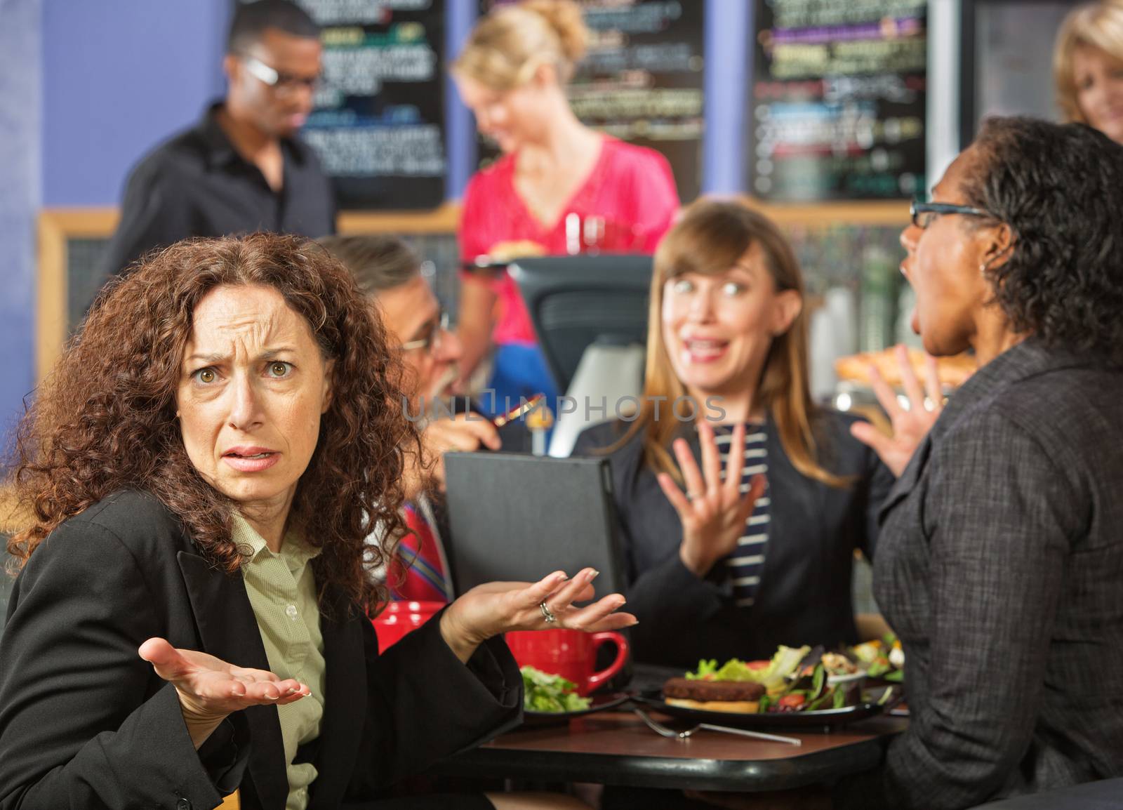 Irritated business woman with coworkers in cafeteria