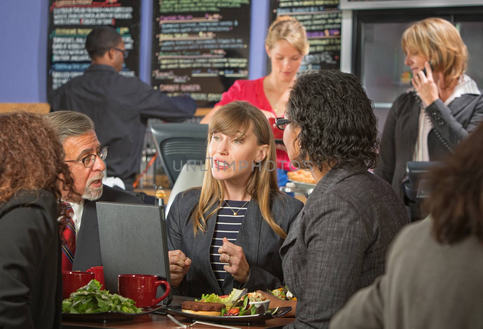 Diverse group of business people eating lunch in cafeteria