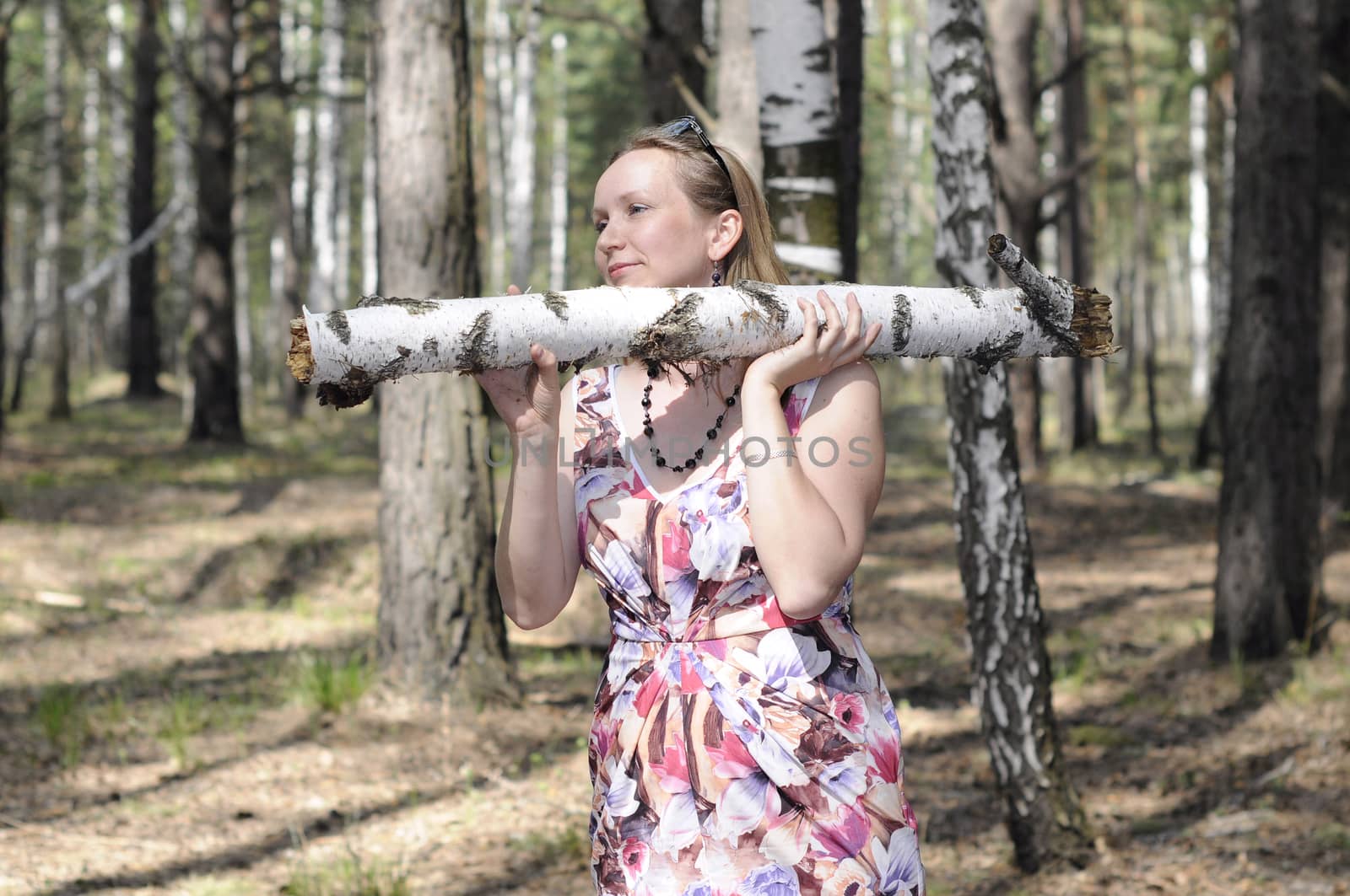 The young woman with a log in the wood