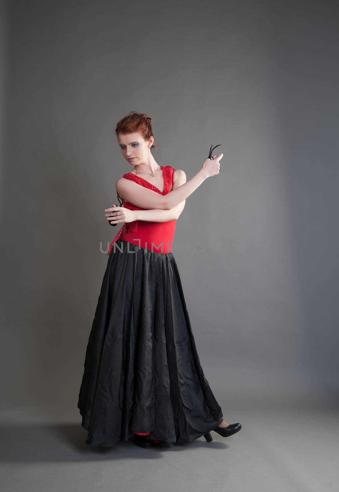 flamenco dancer swinging skirt on a grey background