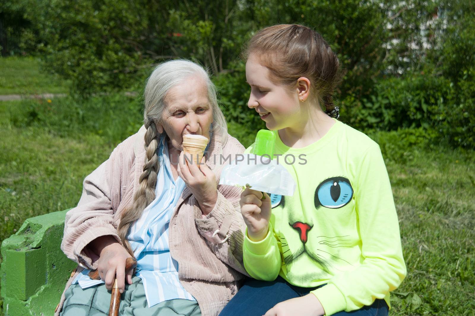 grandmother with her granddaughter, eating ice cream in the summer