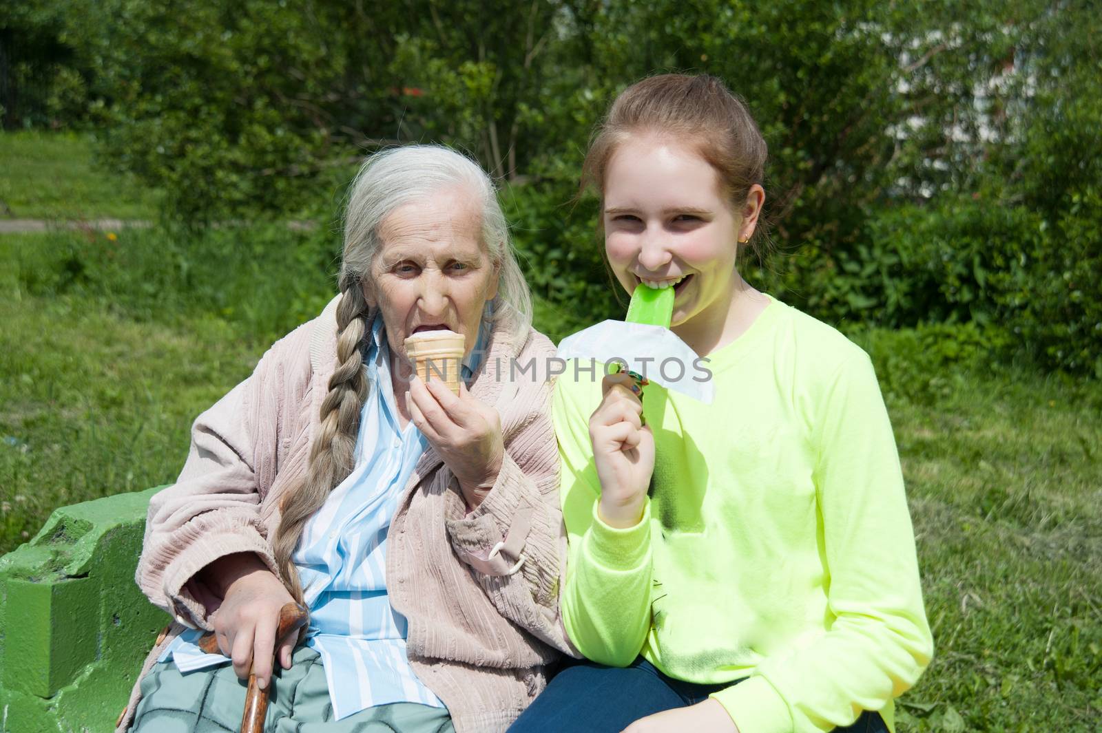 grandmother with her granddaughter, eating ice cream in the summer