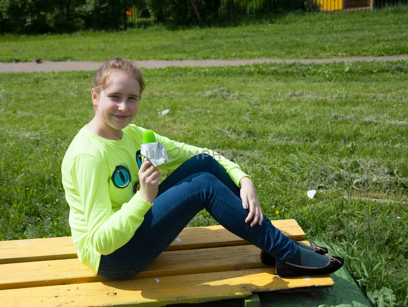 joyful girl eating ice cream in the summer in the Park