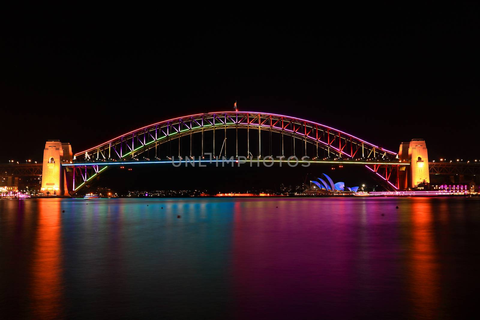 SYDNEY, AUSTRALIA - JUNE 2, 2014;  Sydney Harbour bridge iilluminated n various vibrant colours and water reflections,during Vivid Sydney snnual festival events.