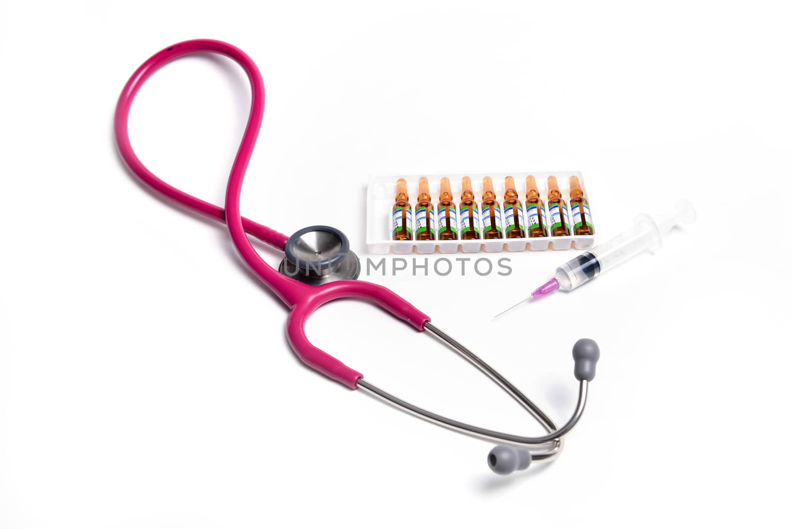 ampule syringe and stethoscope on white table