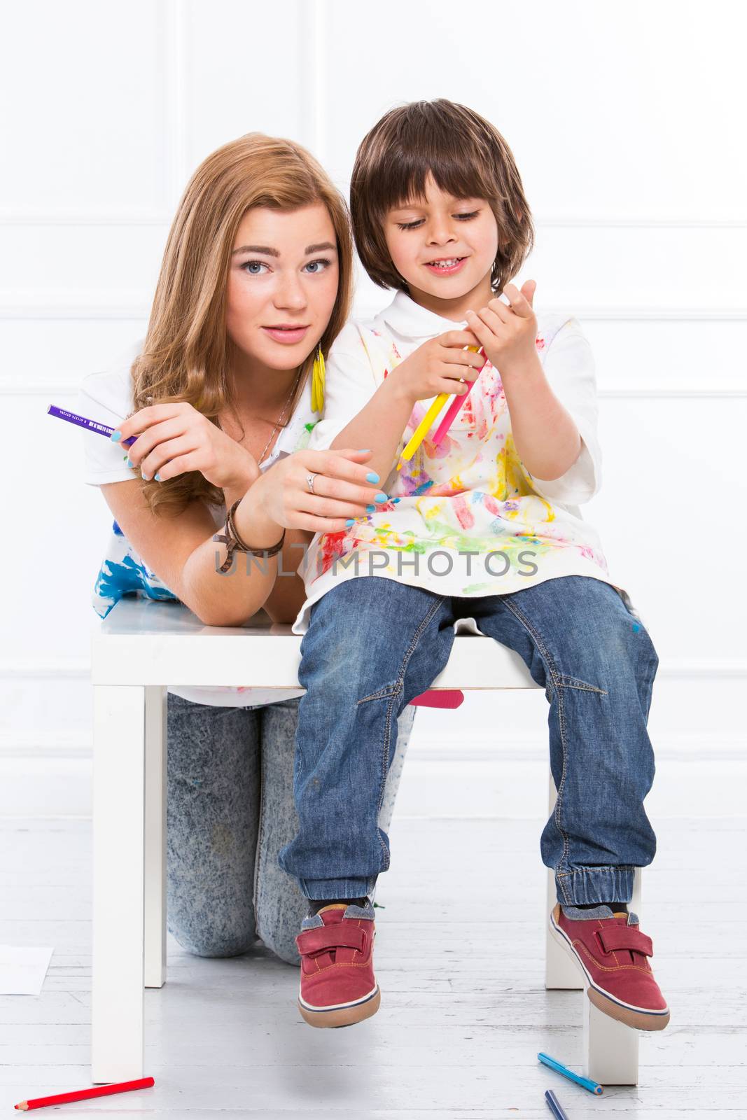 Cute, adorable boy with mother painting on the floor