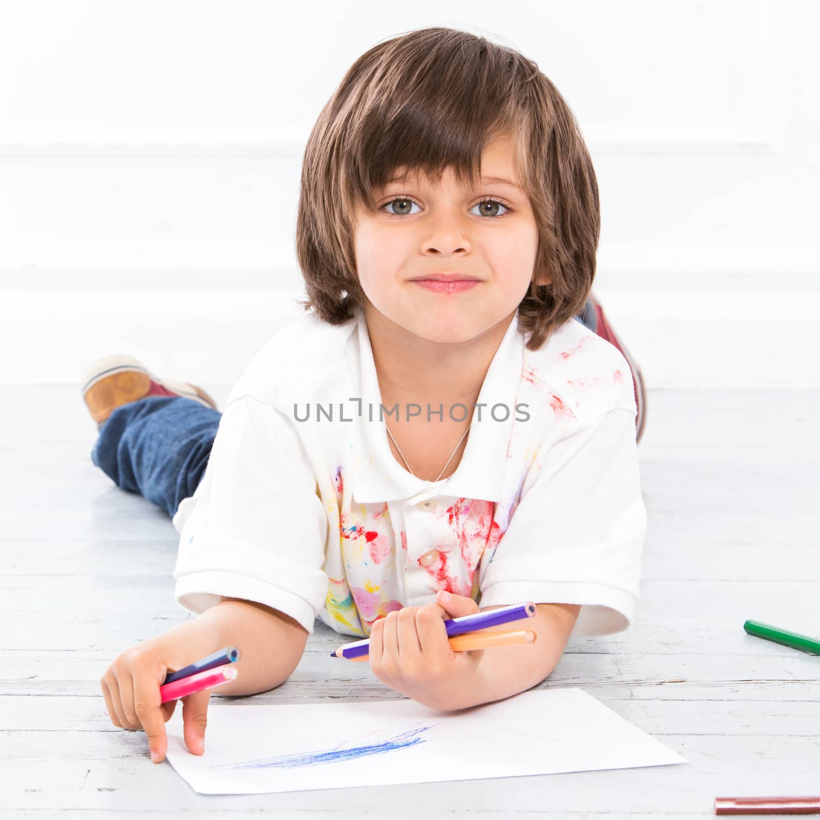 Cute, adorable boy with pencils on the floor