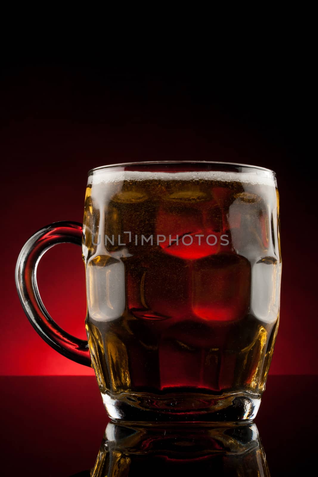 back lit glass mug with beer with reflection