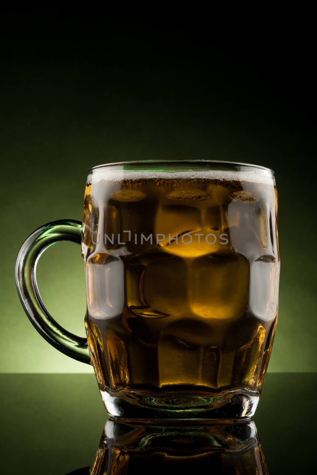 back lit glass mug with beer with reflection
