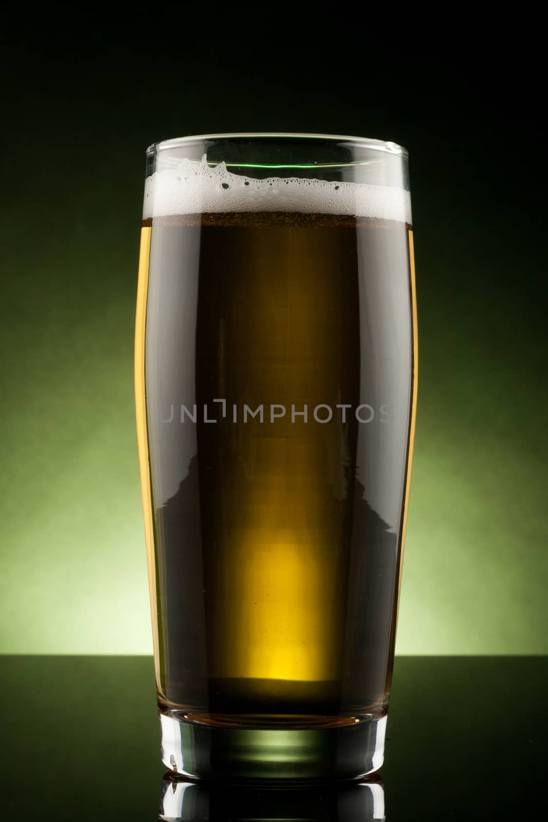 back lit glass of beer with reflection