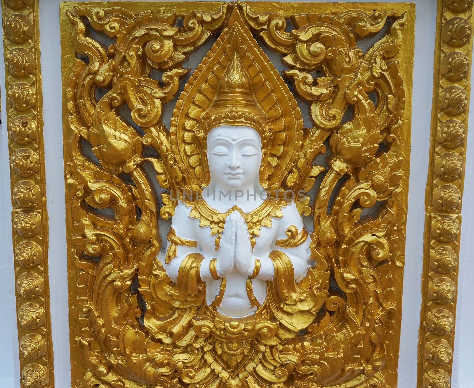 Images carved angel, gold-painted on the wall of the temple in Laos.                               