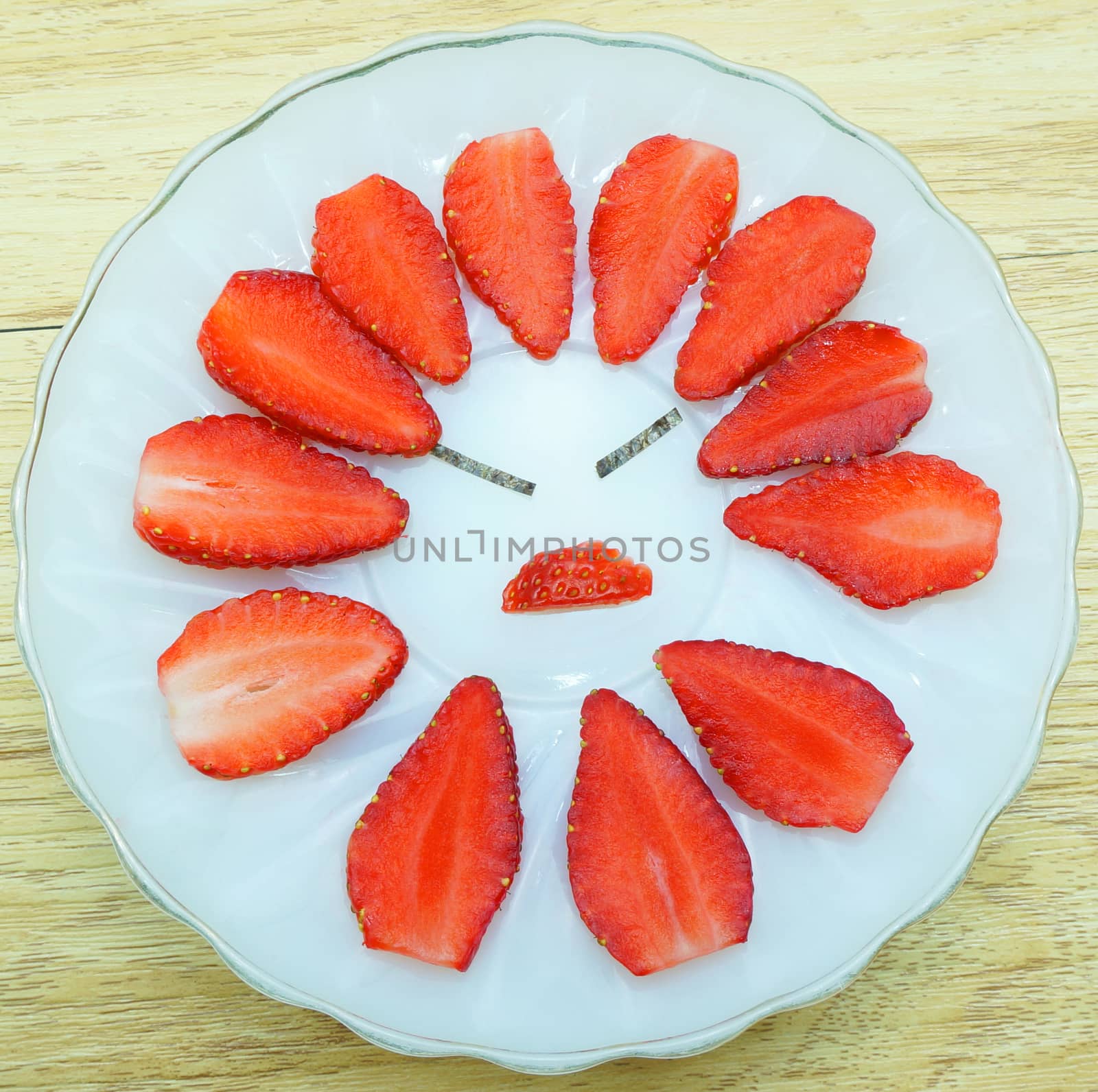 Strawberry slice, arranged in a circle. Decorative eyebrows and mouth, it seems people are angry.                              