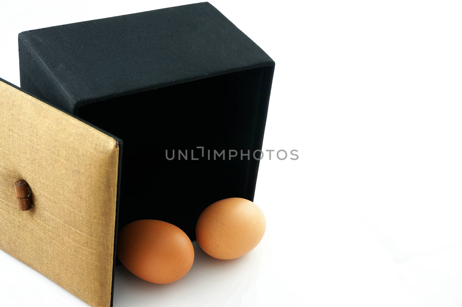 Eggs in a black box, with the lid brown. A symbol of the start of something new.