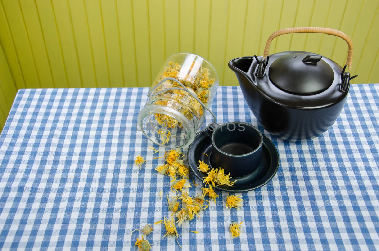 jar dried coltsfoot on table black ceramic tea pot by sauletas
