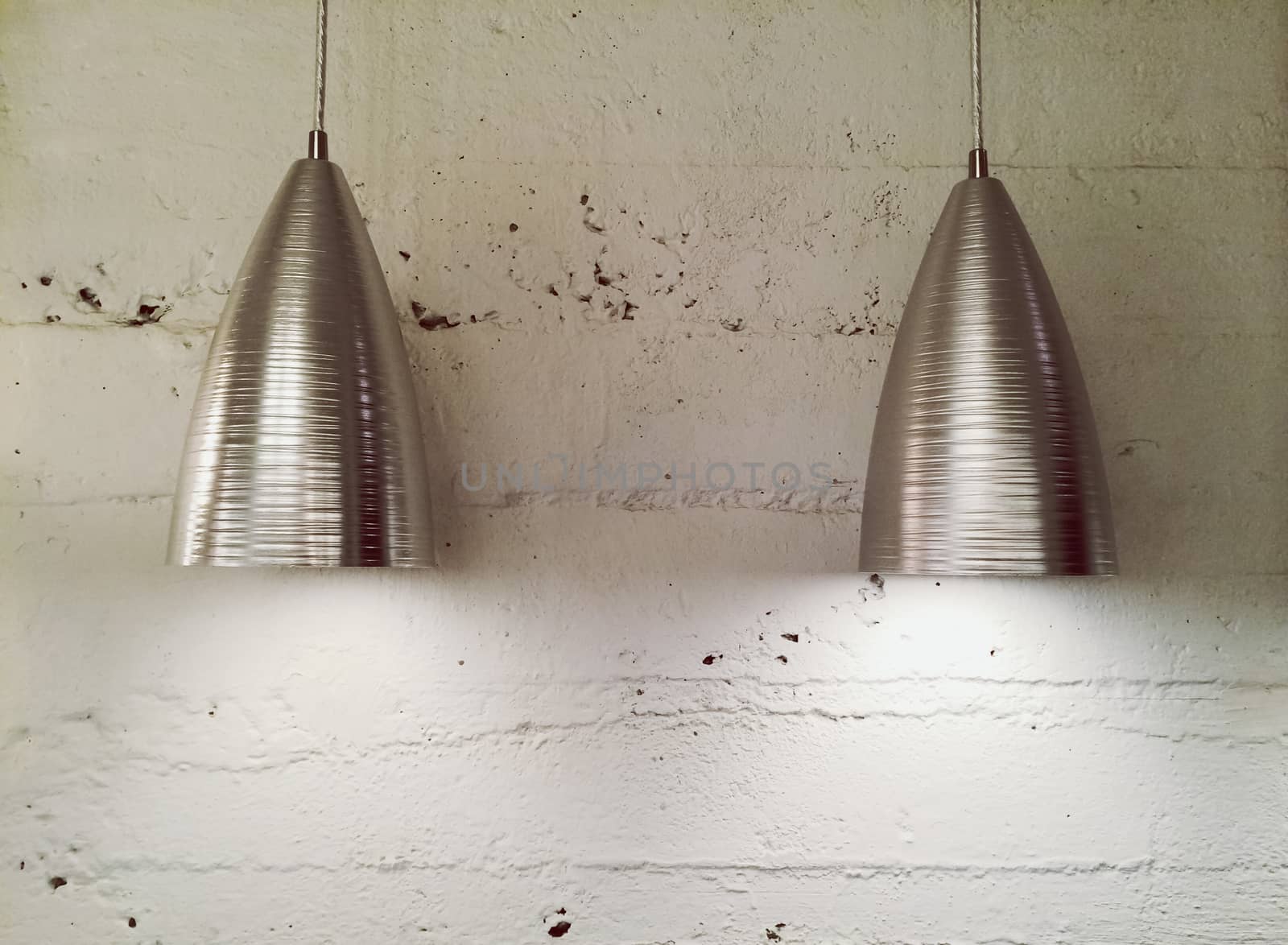 Two metal lamps near white wall. Contemporary design. 