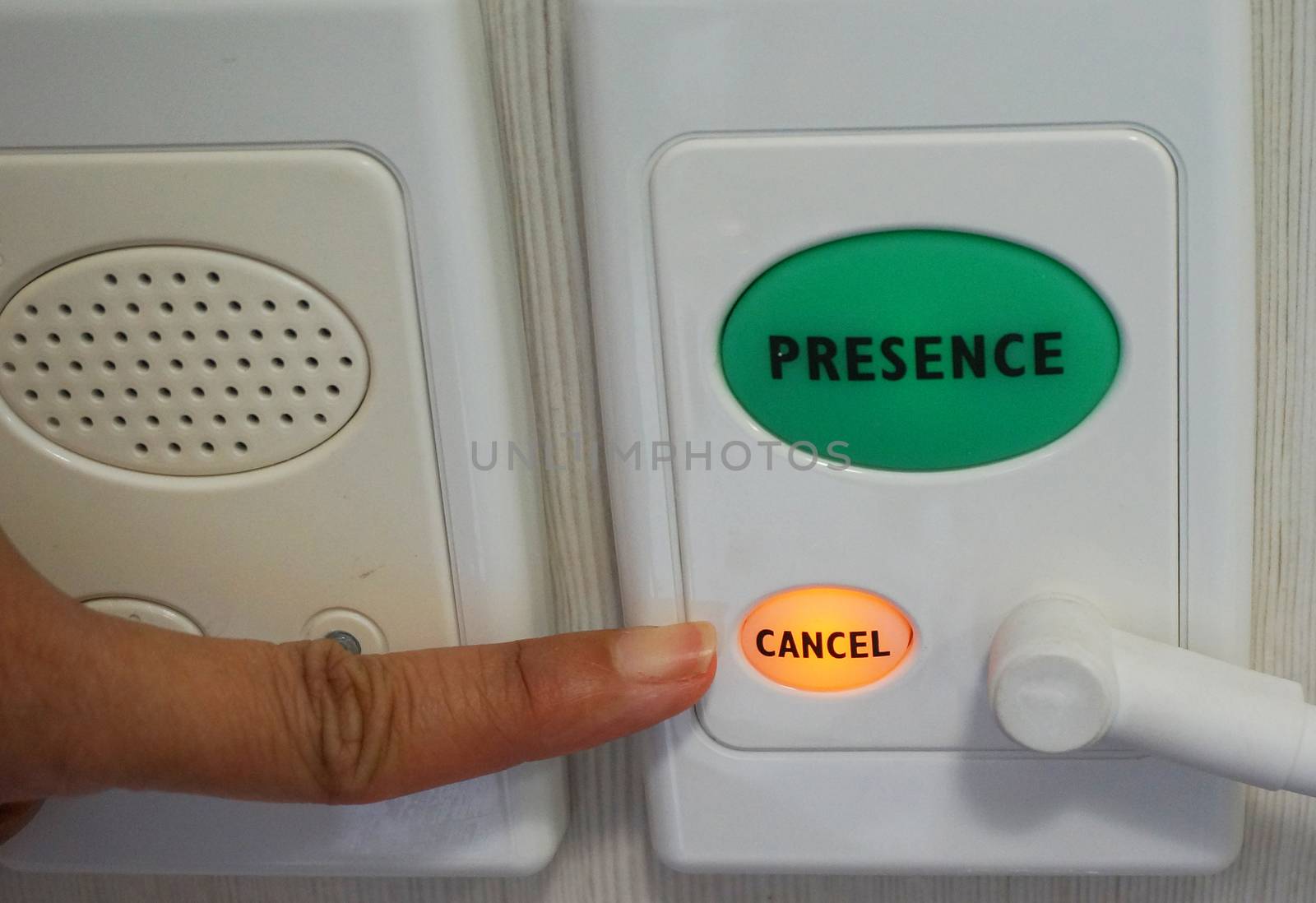 Human finger pushing button of hospital intercom used for nursing call.                           