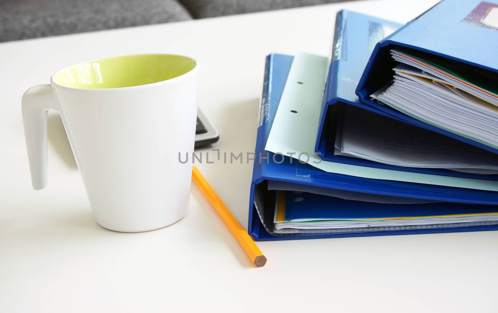 Working papers arrange on a dark blue folders, Placed on a table with a glass of water, pencil, calculator.                           