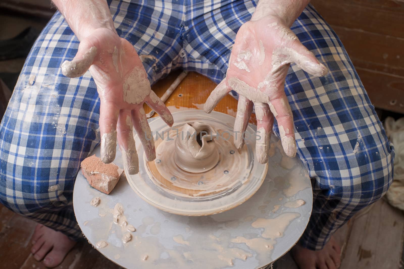 Hands of a potter, creating an earthen jar on the circle