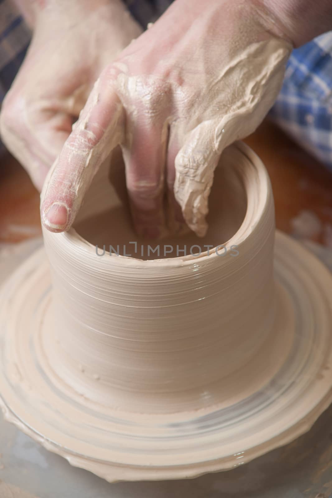 Hands of a potter, creating an earthen jar on the circle