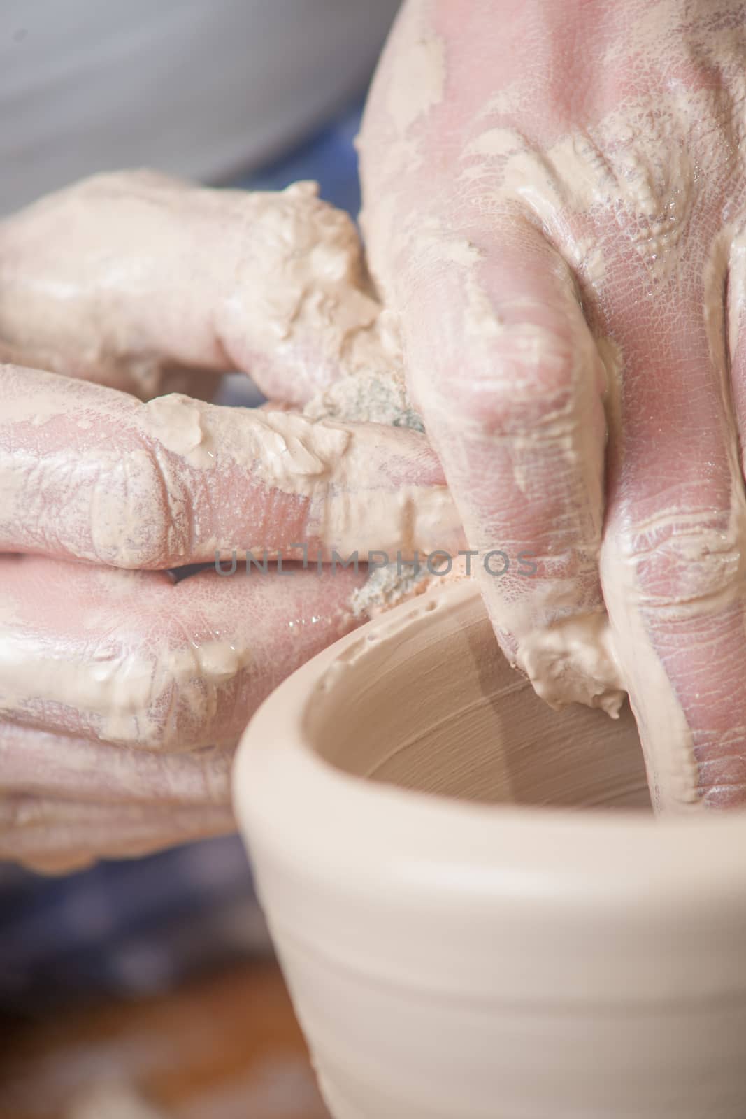 Hands of a potter, creating an earthen jar on the circle