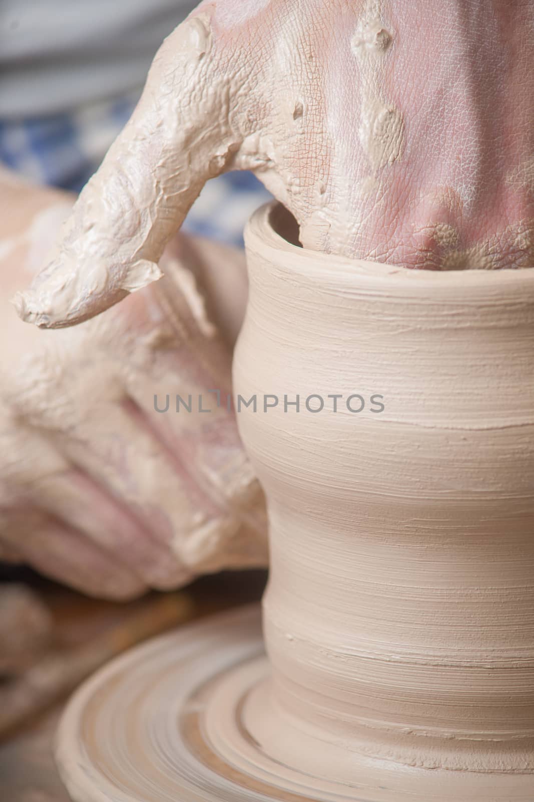 Hands of a potter, creating an earthen jar on the circle