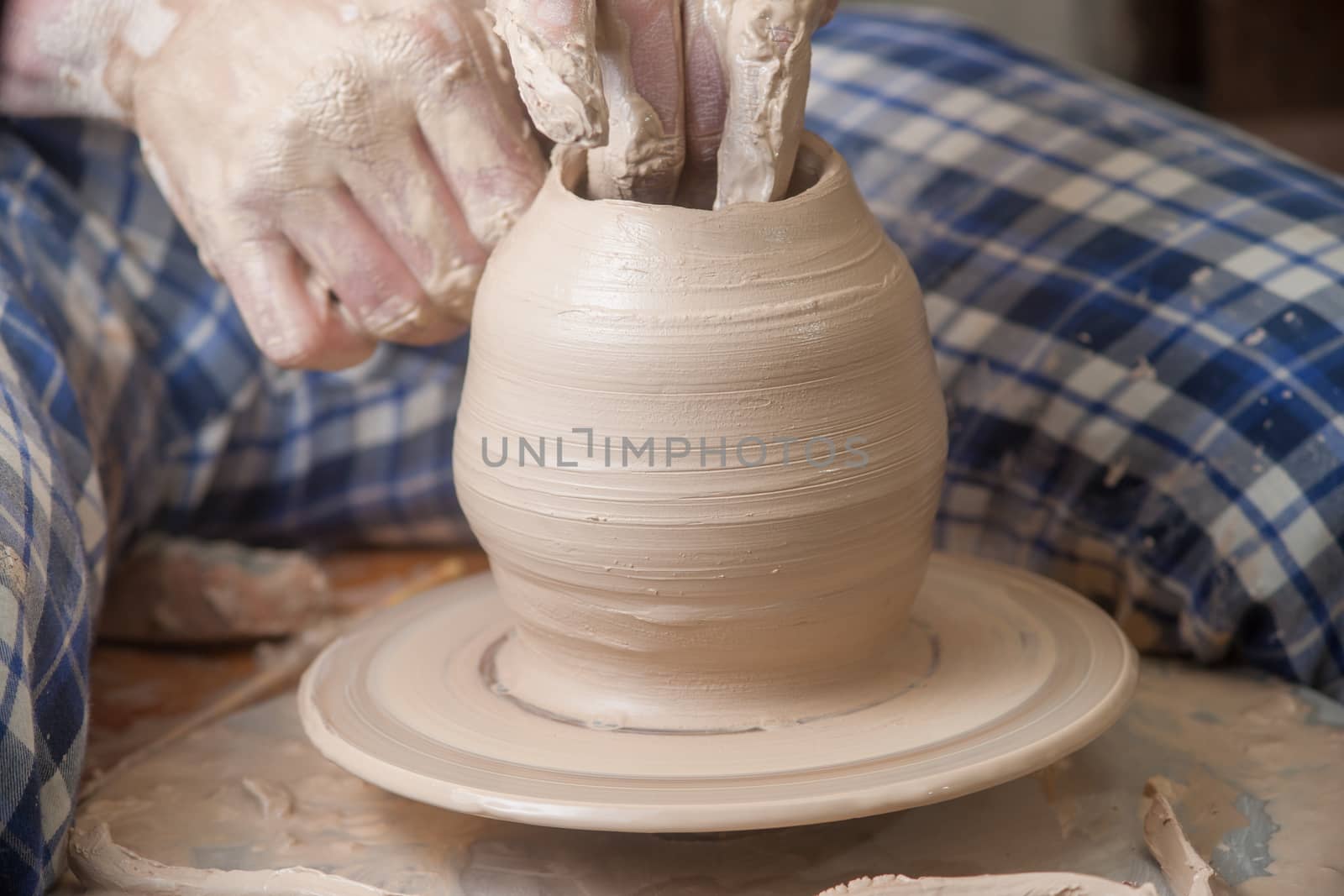 Hands of a potter, creating an earthen jar on the circle