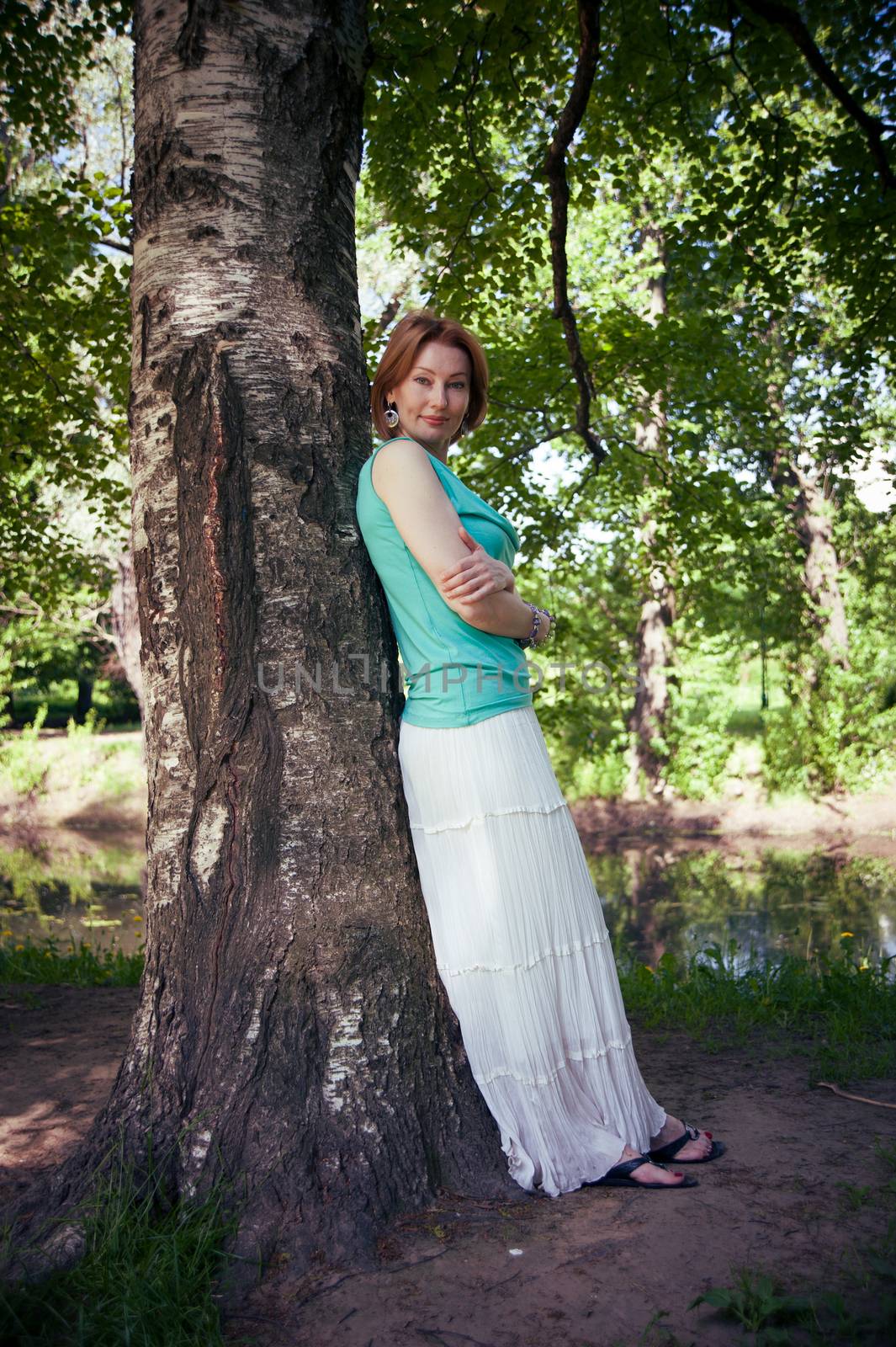 middle-aged woman walks in the Park in the summer of the tree