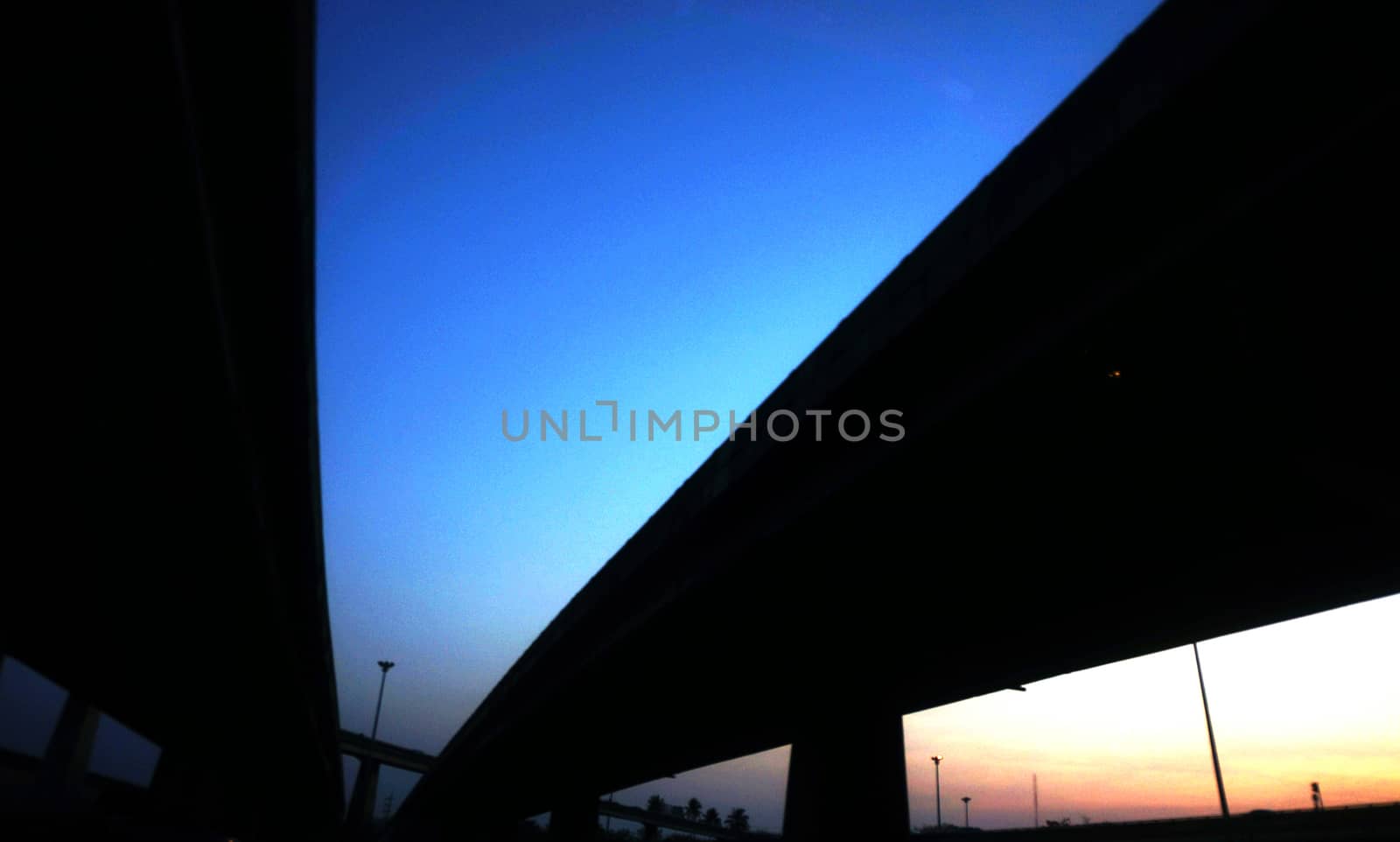 Sky bridges at dusk, the sky split sides blue and yellow.                            