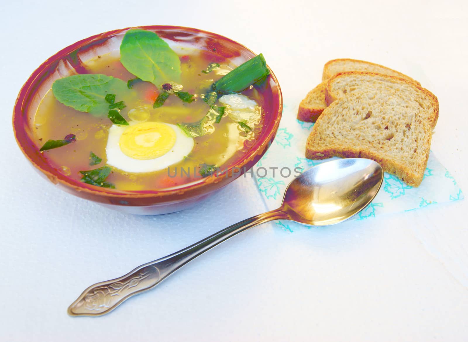 Plate of hot soup and bread on table