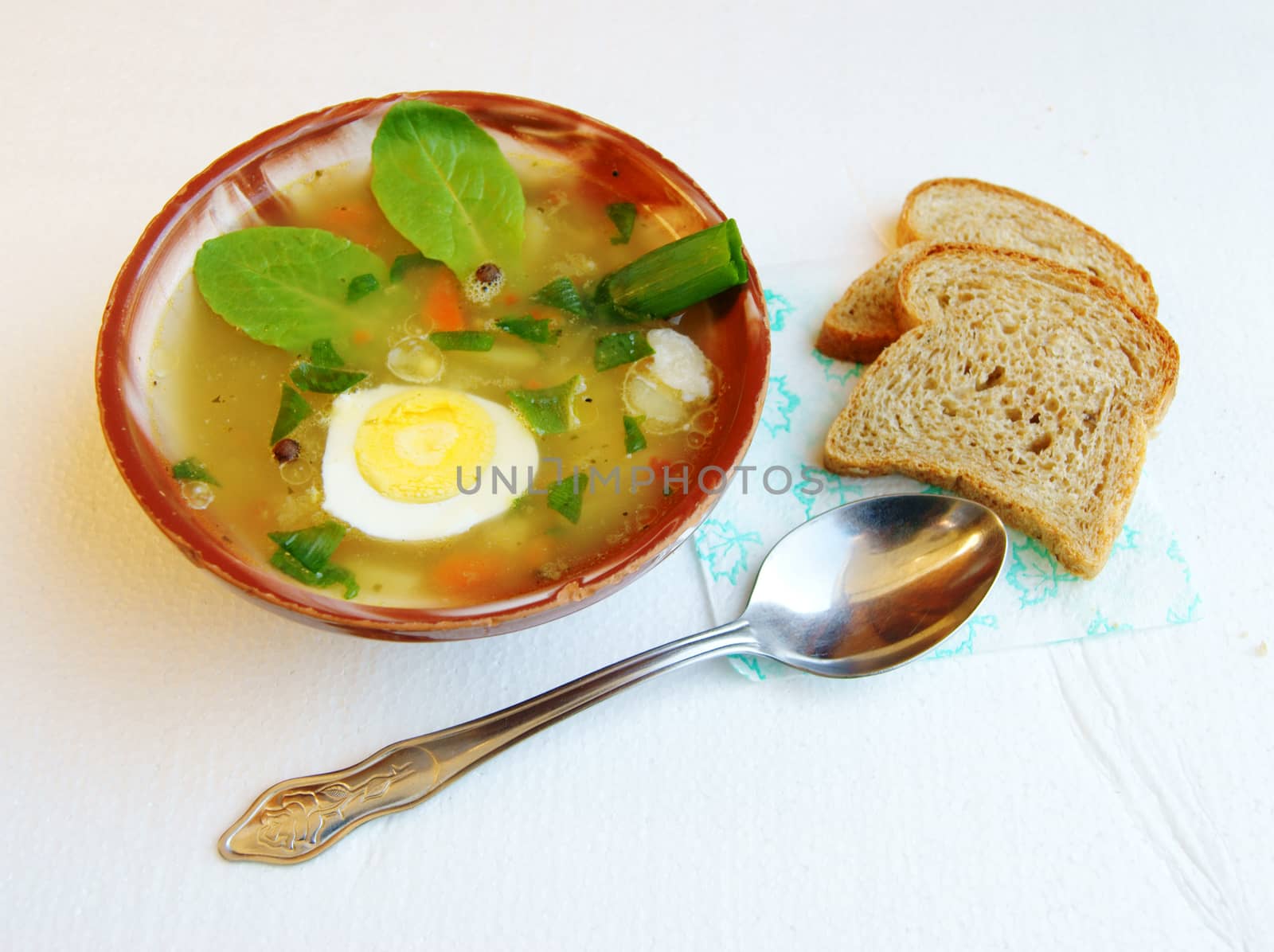 Plate of hot soup and bread on table