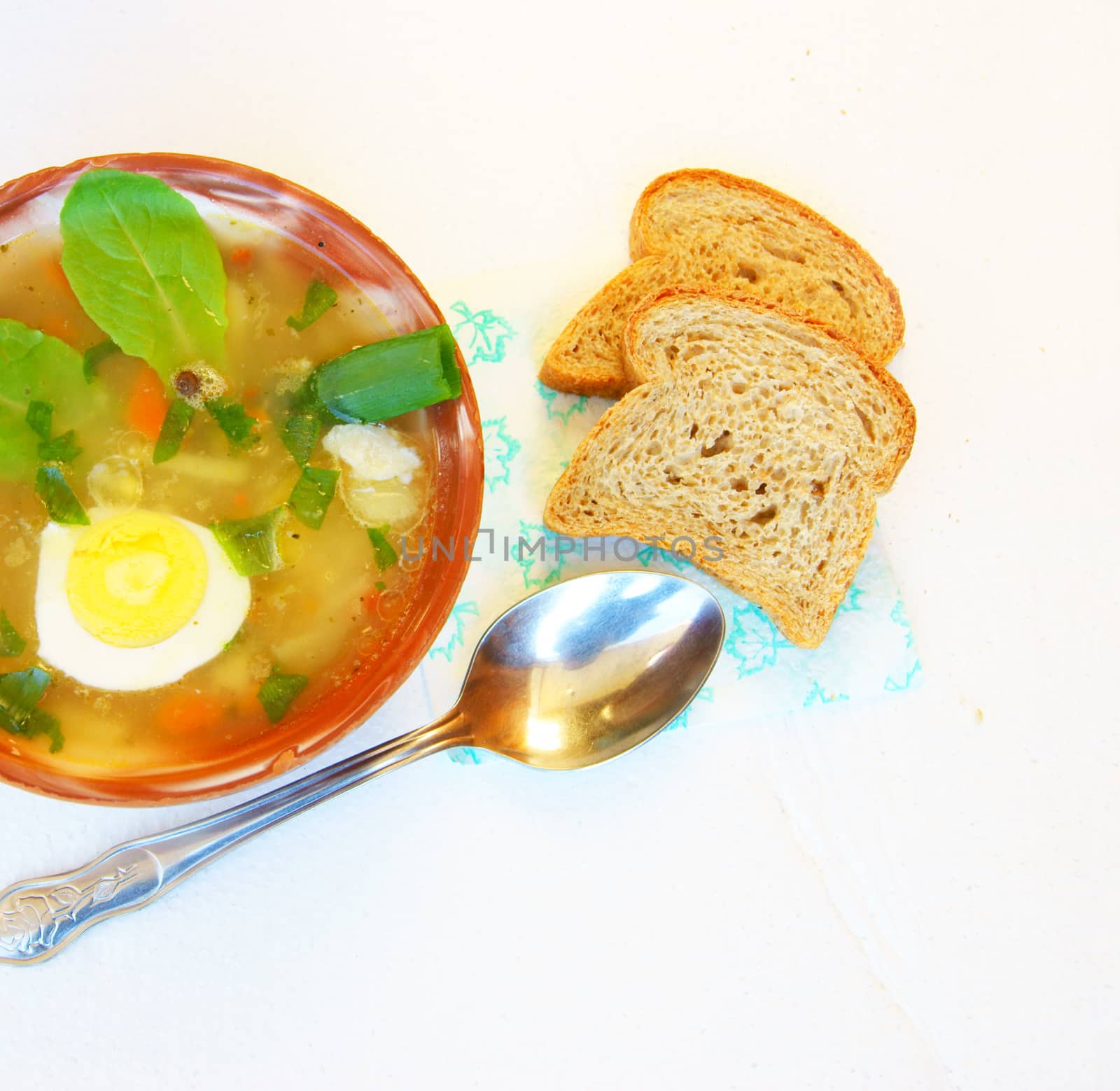 Plate of hot soup and bread on table