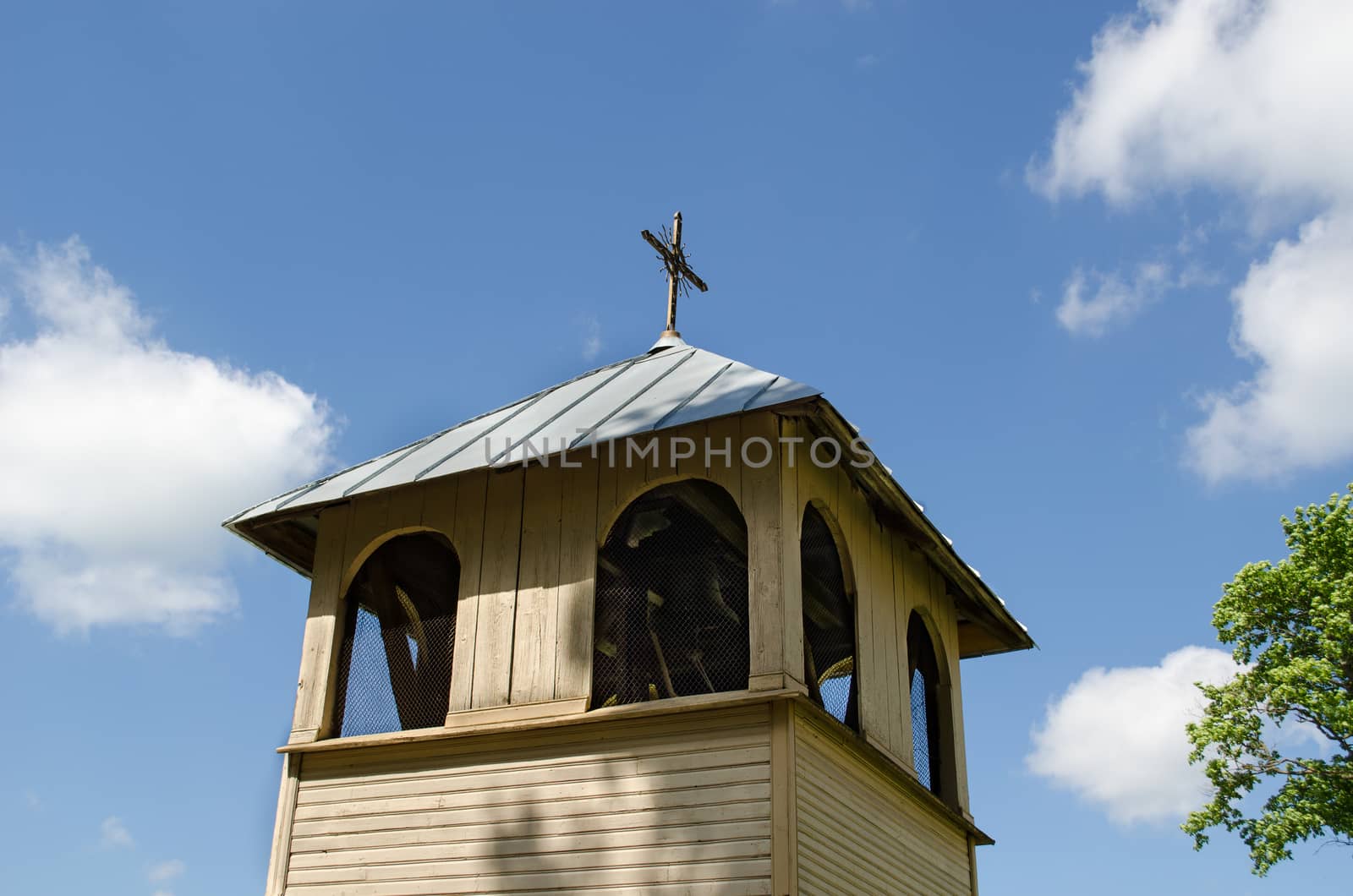 wooden village bell tower on blue sky background by sauletas