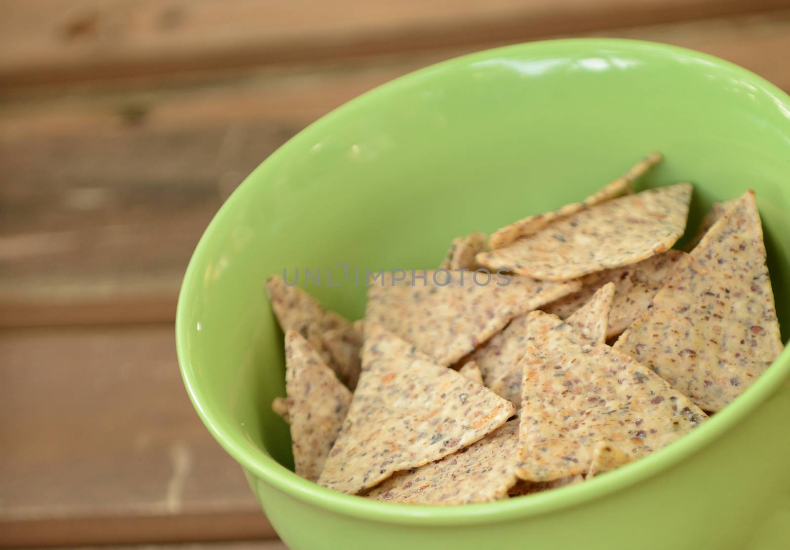 a snack of tortilla chips in a green bowl